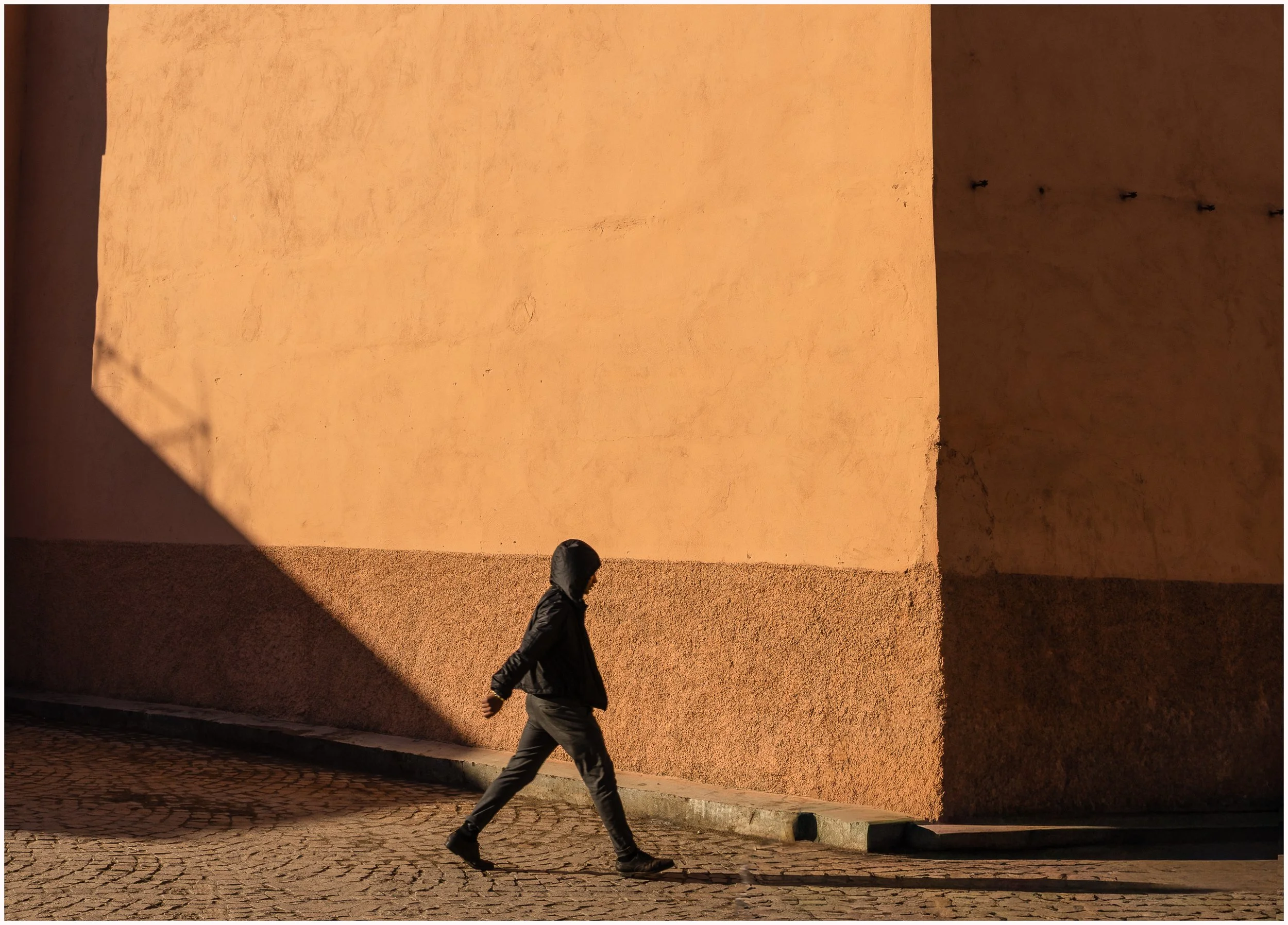 Man walking in Marrakesh with shadows in the street