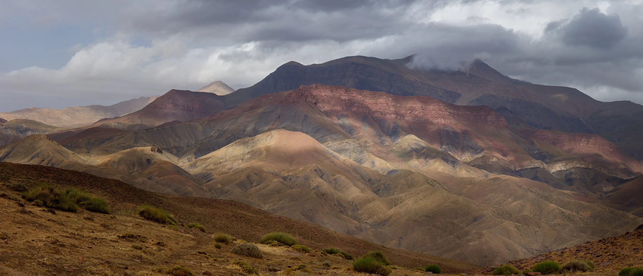 High Atlas mountains in Morocco with red tones and sun shadows