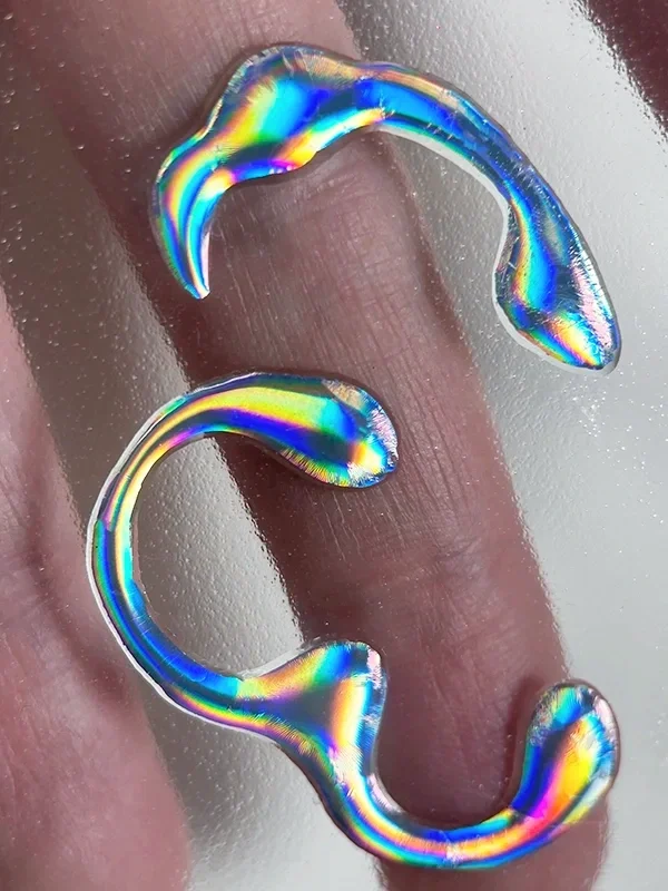 Cutting out fully dried metallic eyeliner shapes to create reusable elements for face chart designs.