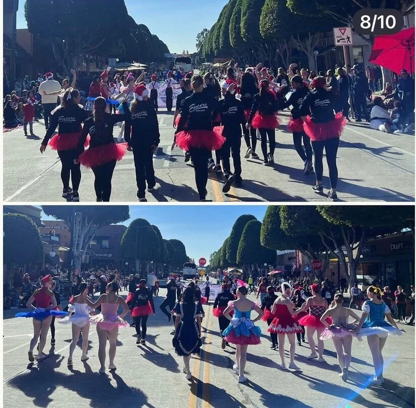 Group of women and children dressed in colorful ballerina costumes participating in a parade on a sunny street lined with trees and spectators.