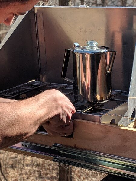 lighting camp stove to make cowboy coffee