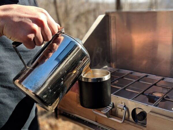 pouring fresh percolator camping coffee into yeti mug