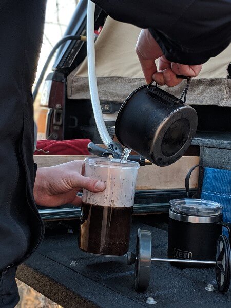 adding hot water to gsi javapress to make french press camping coffee