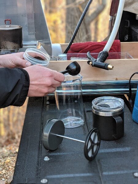 putting coffee grounds into gsi javadrip to make camping coffee