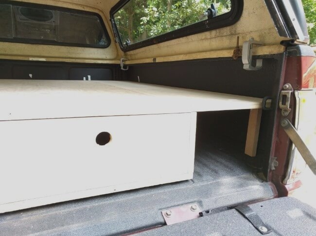 removable section of sleeping platform in place in pickup camper