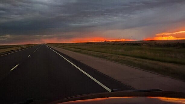 sunset on highway during family road trip with toddler