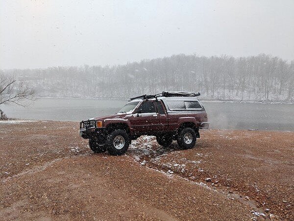 toyota truck camper near lake in snow