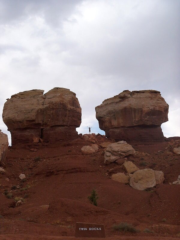 woman standing between twin rocks in utah national park