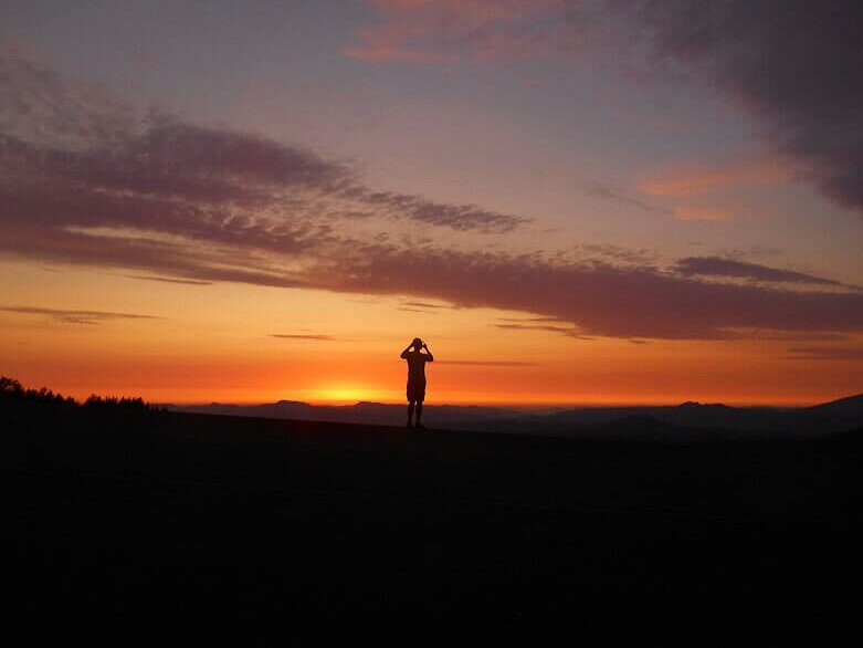 bright orange sunset with silhouette of man