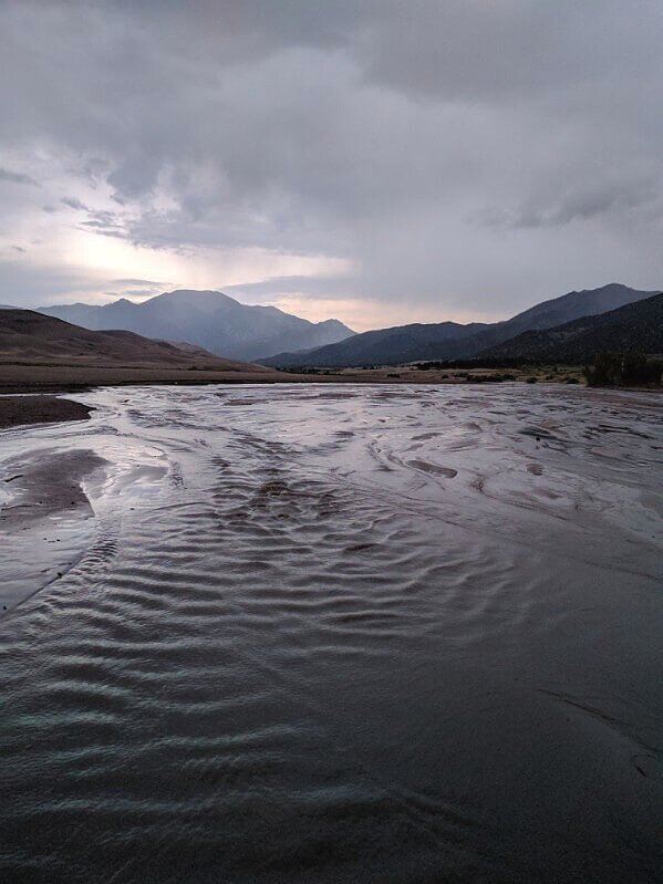 wide medano creek in evening with mountains and sand