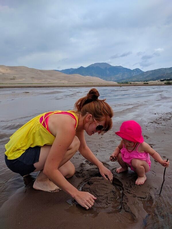 toddler and woman playing in sand at medano creek