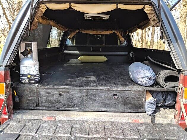 foam sleeping pad rolled up on a truck bed sleeping platform