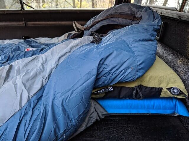 truck bed mattress or suv mattress using inflatable sleeping pad and pillow while truck camping