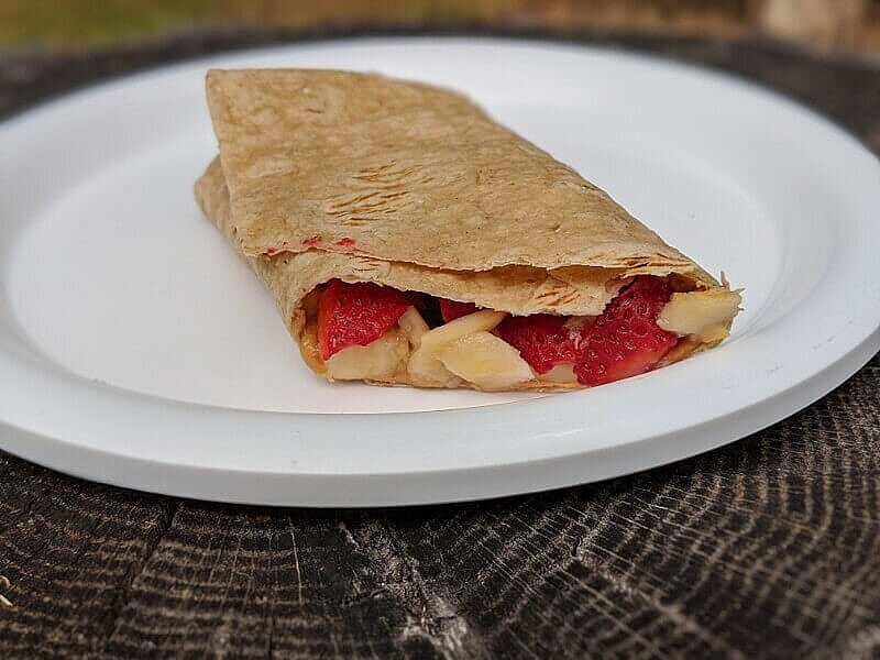 Easy camping breakfast of fruit and nut roll up.