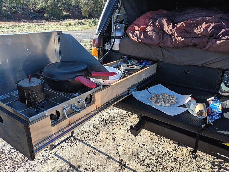 gear for cooking and camping in the bed of a pickup truck