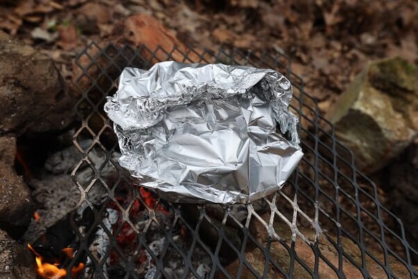 Campfire pizza in foil over hot coals