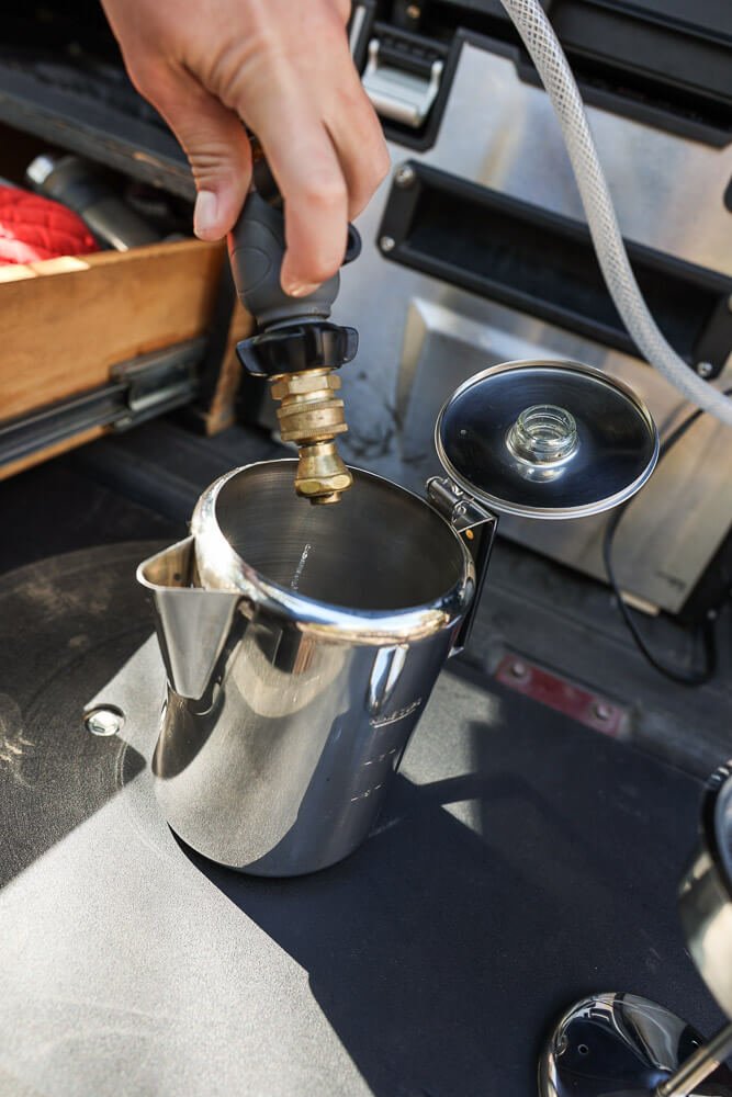 adding water to the camping coffee percolator