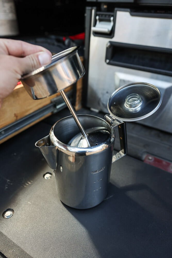 gourmet coffee percolator precariously balanced on a gas camping