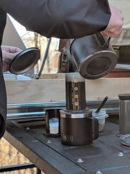 adding hot water to the aeropress coffee grounds while camping