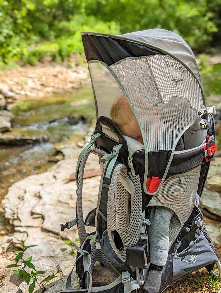 using camping gear for baby sleeping in backpack carrier after a hike while camping