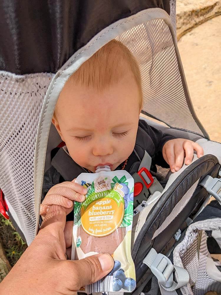 baby enjoying a snack while camping