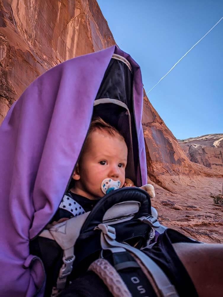 baby playing with toys attached to baby camping gear tether strap while hiking
