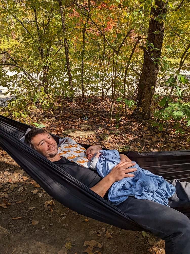 baby napping in hammock with dad while camping