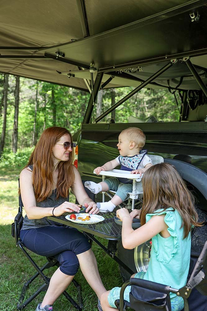 family eating while camping with baby in camping highchair