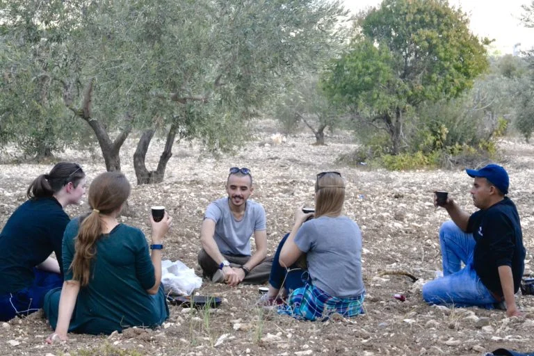 The group relaxing with a cup of tea while taking a break from a hike.