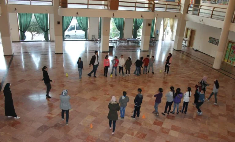 Academic students line up to play a racing game to practice English letters and numbers.