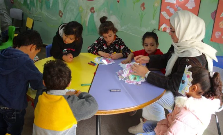 Core Early Childhood students and a volunteer work together to create lion masks.