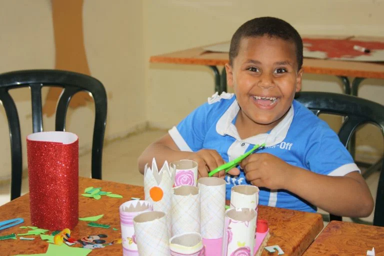Core student Mohammad smiles as he works on a project during art class.
