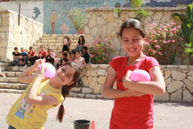 Two Core students Hoor and Yasmine progress to the next round of the water balloon toss while their classmates watch the contest.