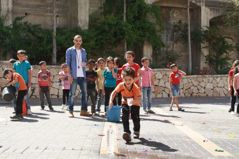 Core student Zain smiles as he rushes to fill the bottle to help his team win the race.