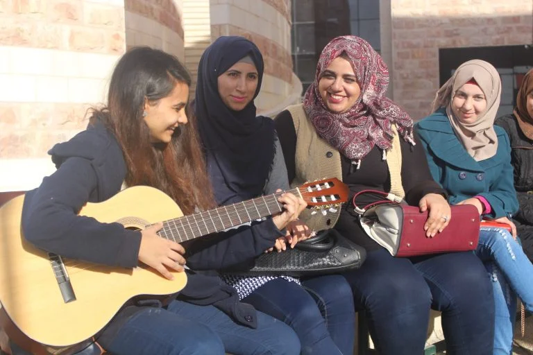Students Nihaya, Rawia, Dania, and Ala’a of the STEP! II EFL program take a break to enjoy some music and sunshine with their classmates.