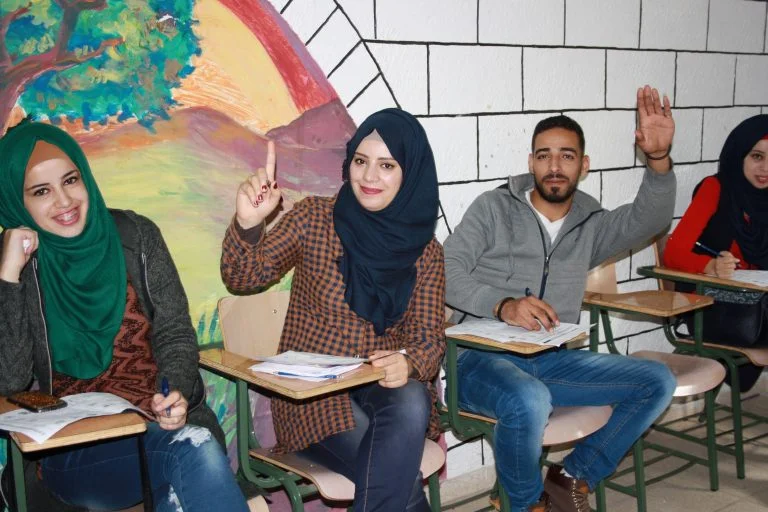 Students of the STEP! II EFL program smile as they prepare to answer a question.