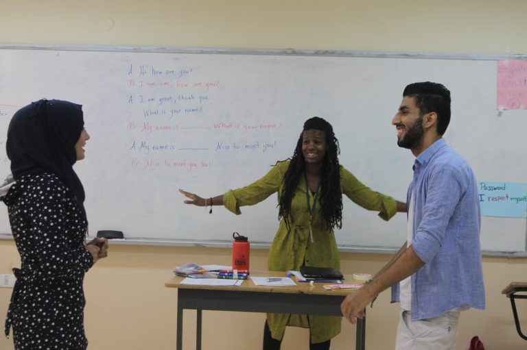 Everyone smiles as they participate in an English learning activity.