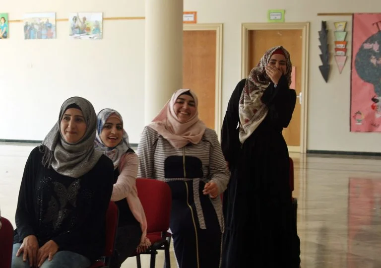 Students laugh together during a word race activity during their STEP! II English class.
