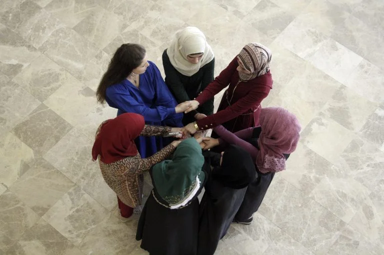 An EFL class plays a game with their teacher on the first day of class.