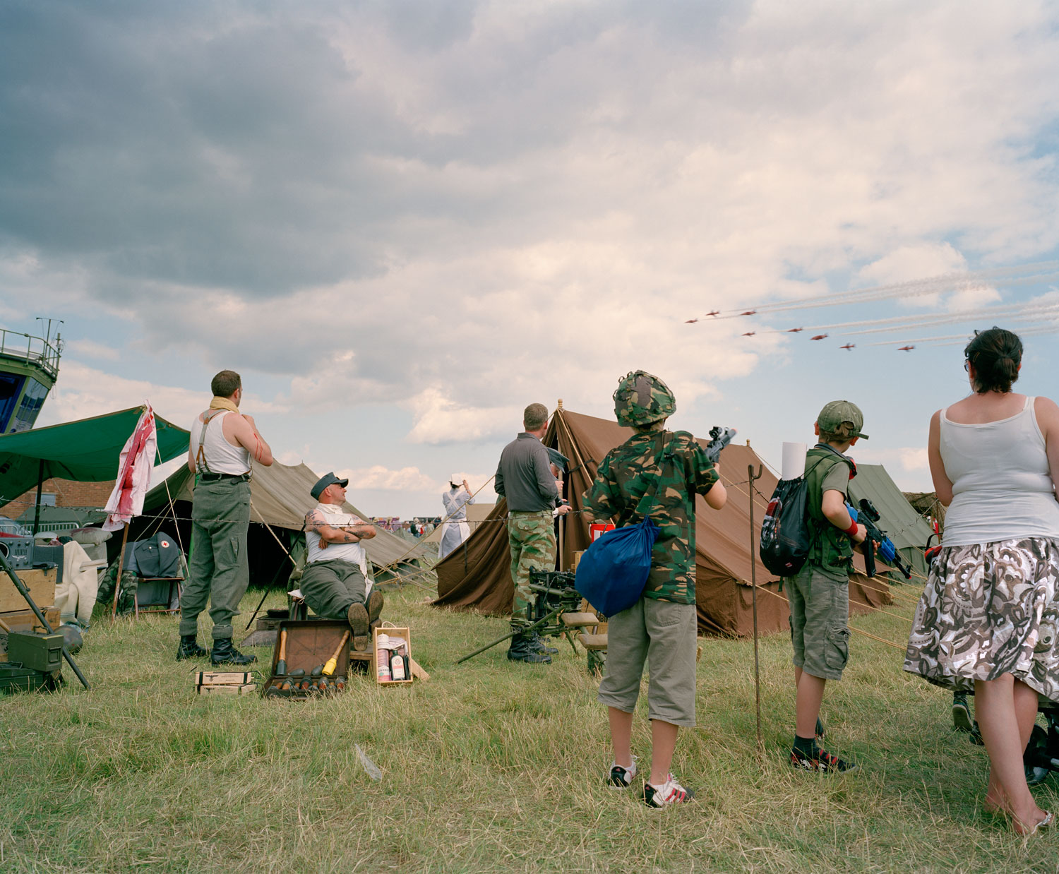  Visitors to the air show and Living History group reenactors watch  display by Hawk T1 military trainers (Red Arrows), RAF Waddington  International Air Show, Lincolnshire, 2 July 2011 