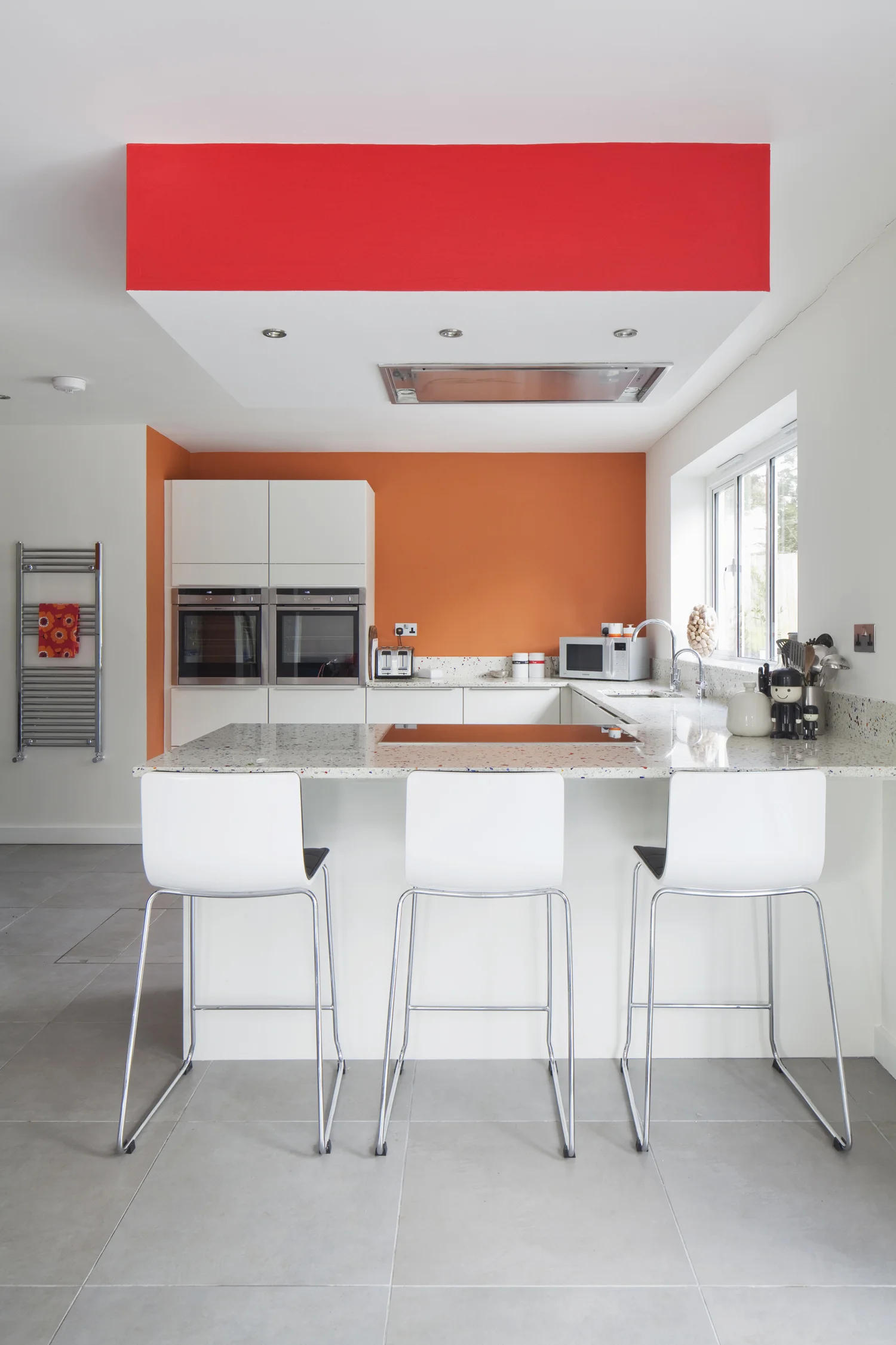 modern white kitchen with pops of orange