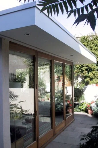 contemporary garden room with glazed doors and roof overhangs with lighting in soffit