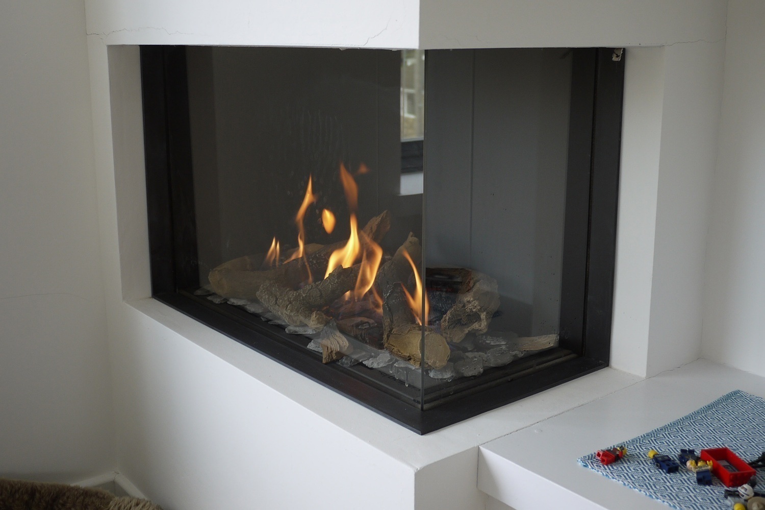 cosy fire in contemporary corner fireplace