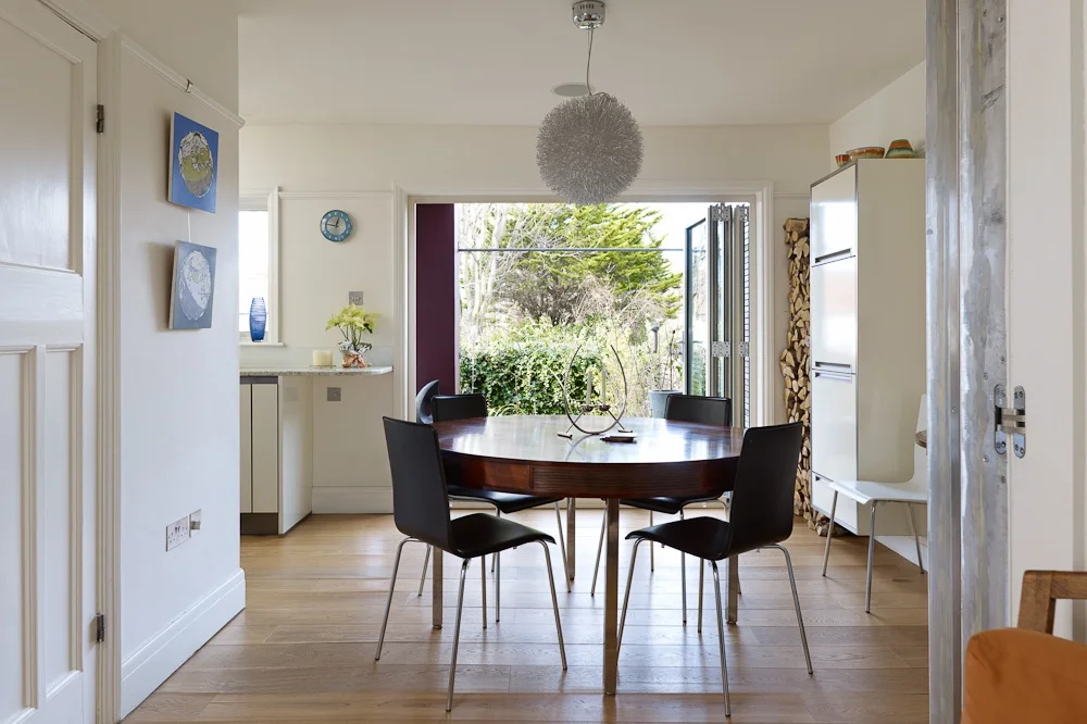 dining area spilling into deck and lush landscaped garden