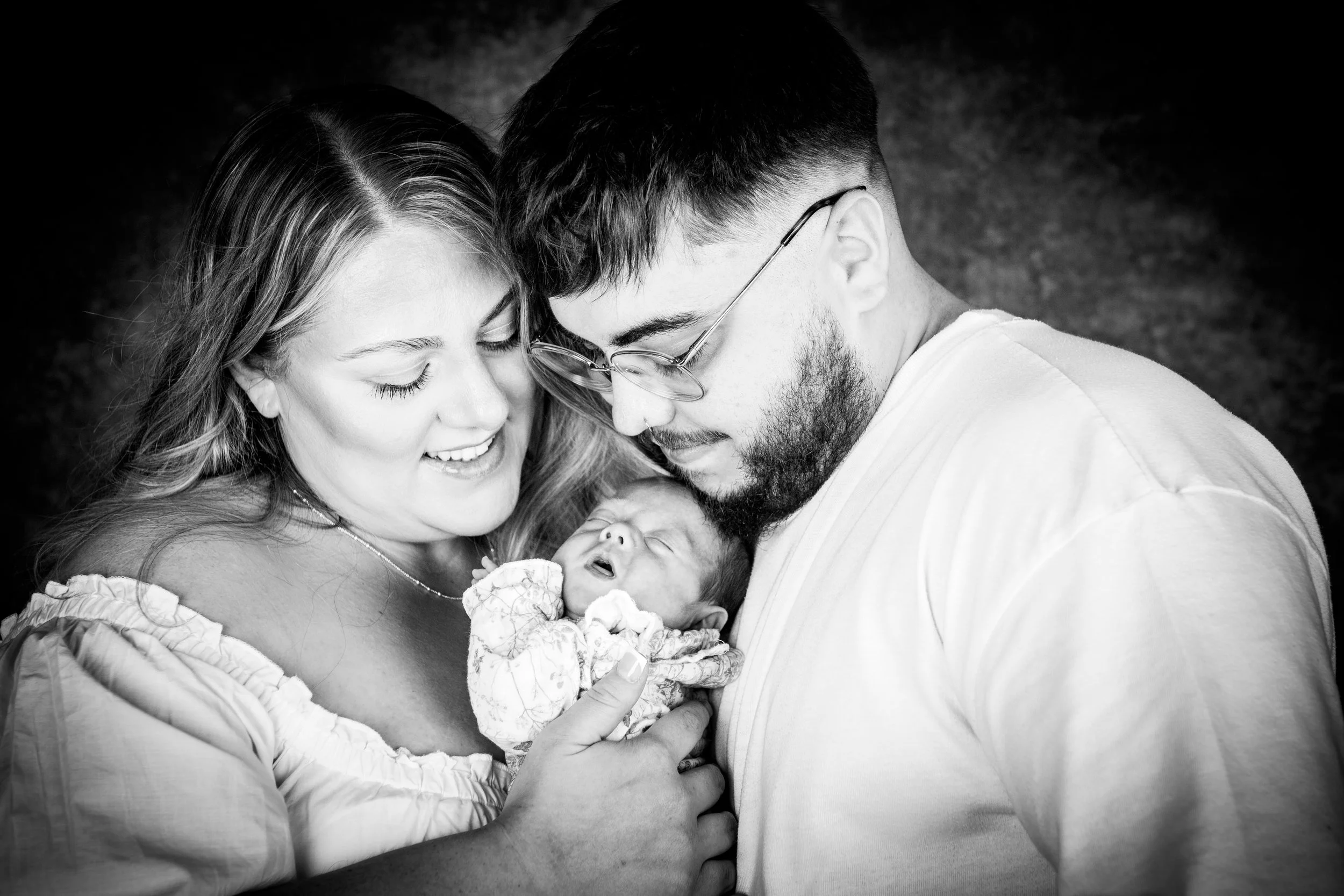 Black and white newborn family portrait by Pontypool photographer showing parents holding baby Ryder