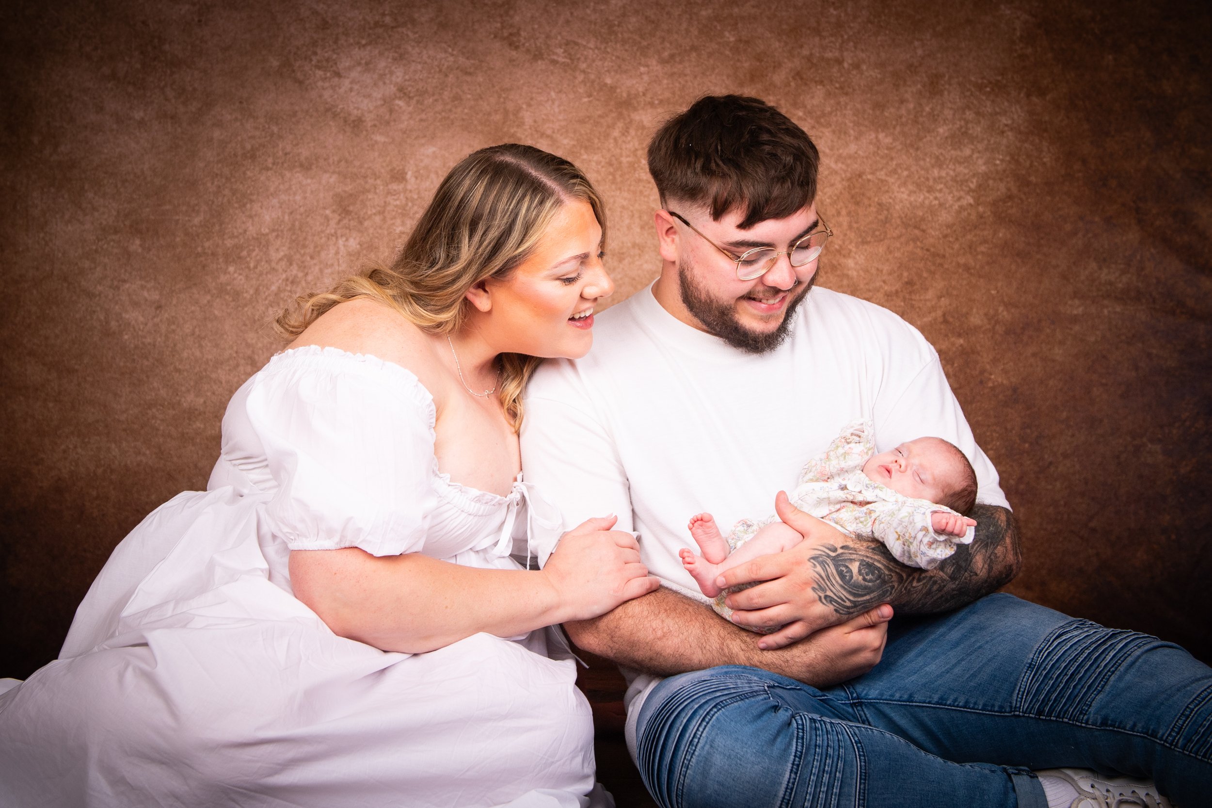 Relaxed newborn family photoshoot in Pontypool studio featuring parents sitting with their newborn baby