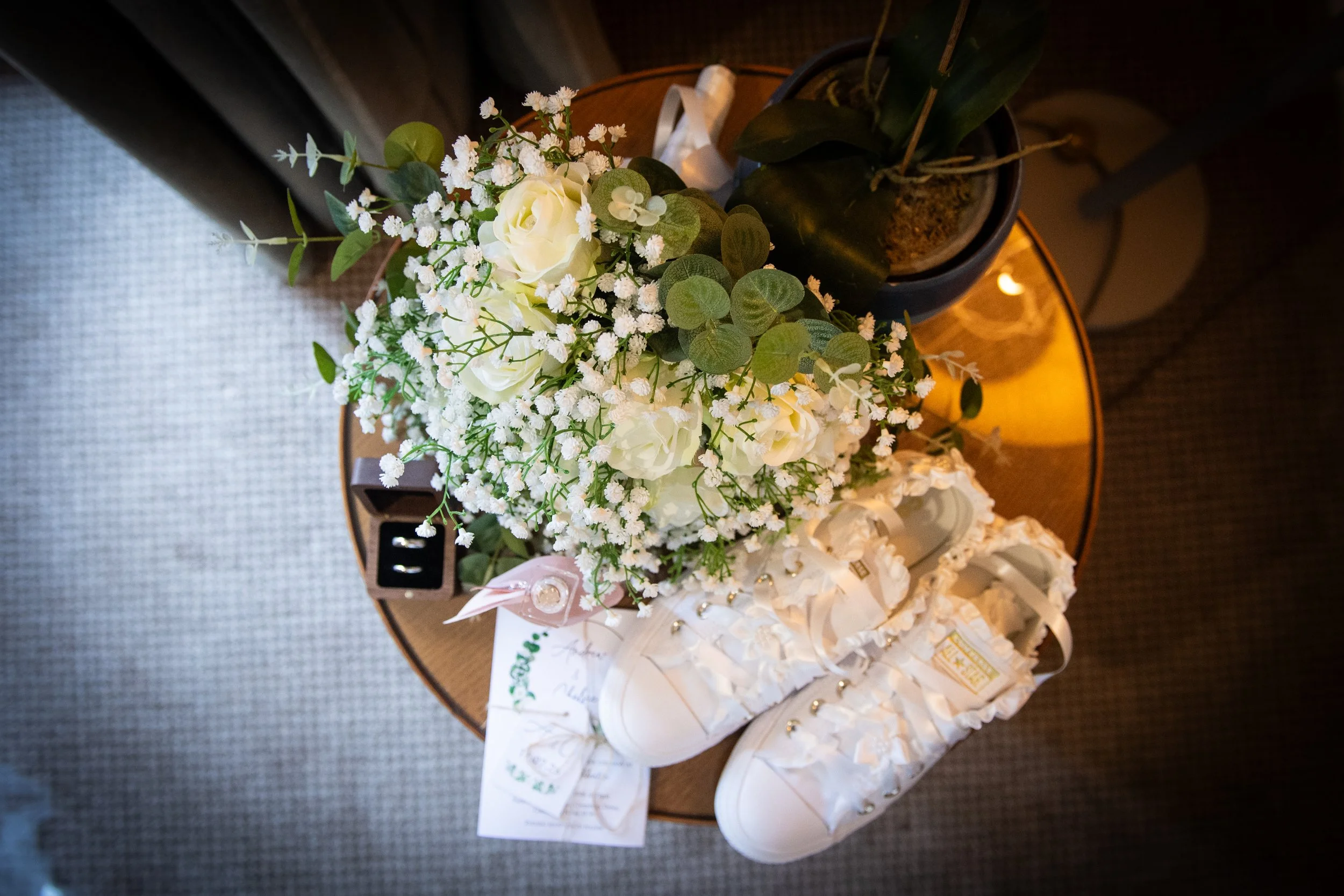 Bridal detail shot featuring a white rose bouquet and customized wedding trainers at a South Wales wedding