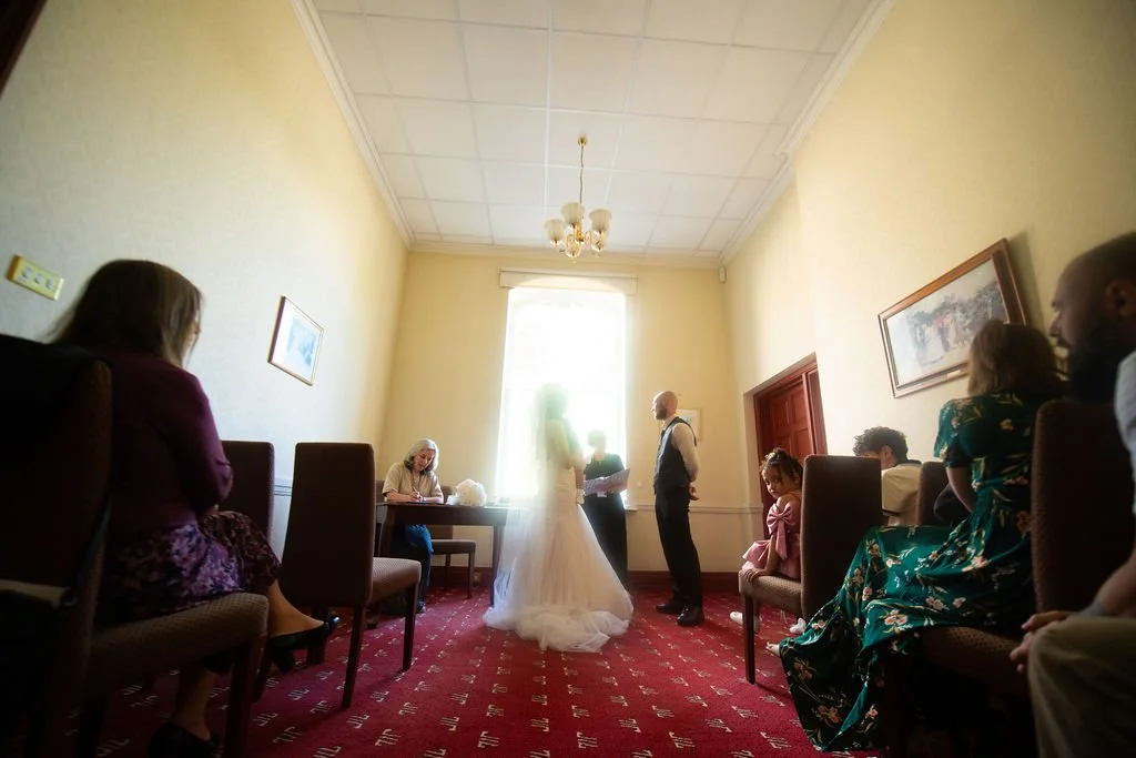 Bride holding her baby during a relaxed registry office wedding ceremony in South Wales