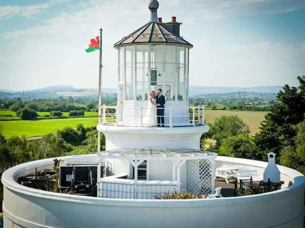 Drone wedding photography by Emotion Picture Photography featuring a bride and groom on the balcony of West Usk Lighthouse in South Wales