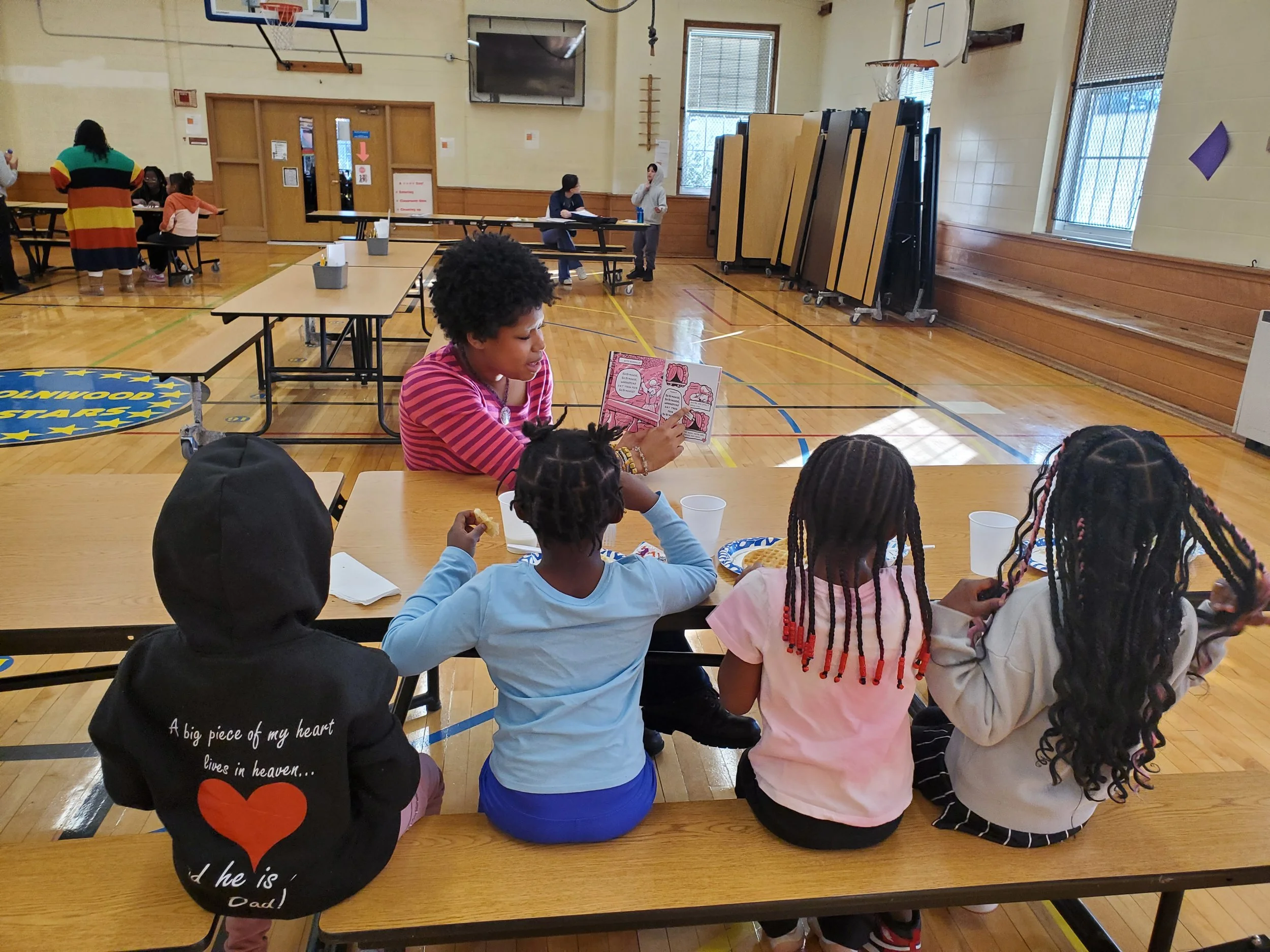 A tutor reads to four students in our Morning Program
